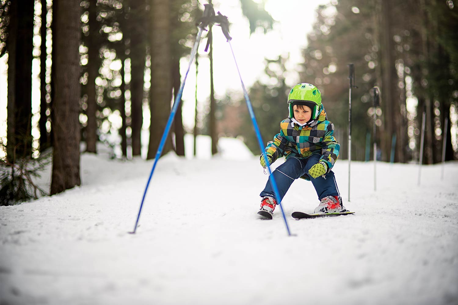 Enfant en chasse neige passant entre 2 batons